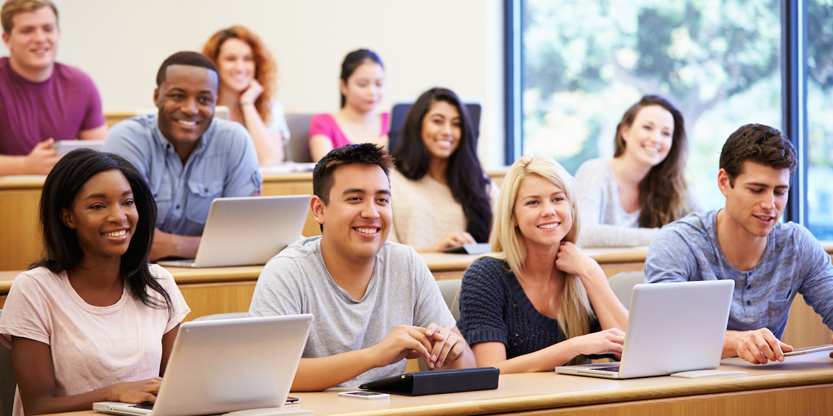 Students Using Laptops And Digital Tablets In Lecture